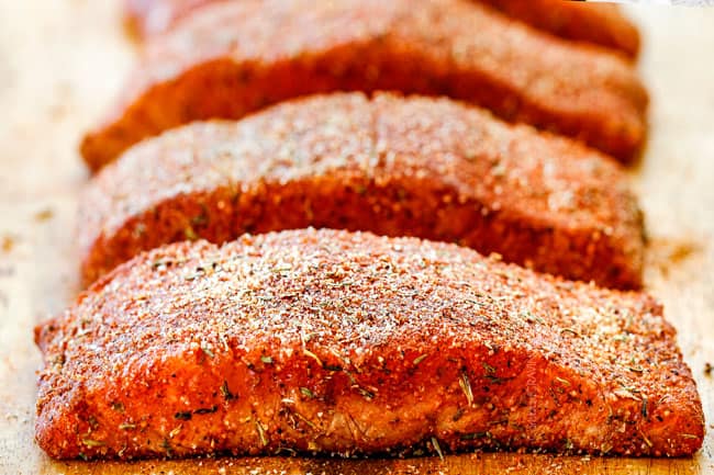  Cajun salmão em uma tábua de madeira com cajun seasoniong caseiro 