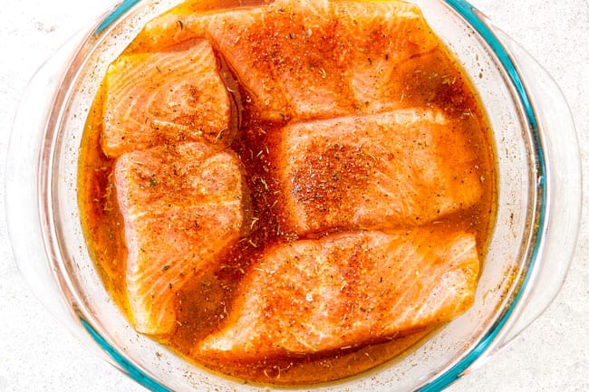  Cajun salmão marinada em uma tigela de vidro com suco de laranja, suco de limão e molho de soja 